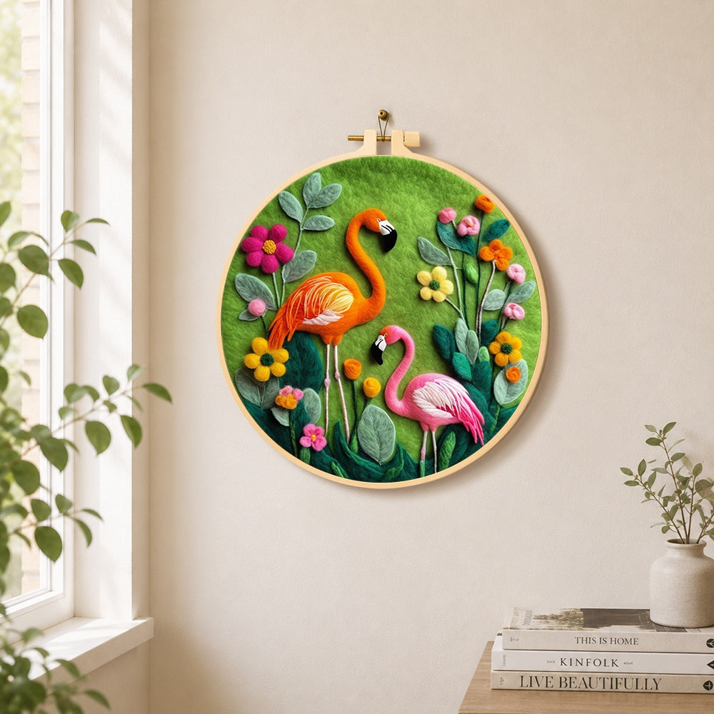 Orange and pink flamingos among flowers needle felt wall art displayed in a bright home interior