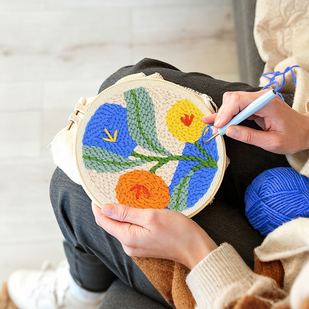 Creating handmade orange, blue and yellow blooms punch needle artwork