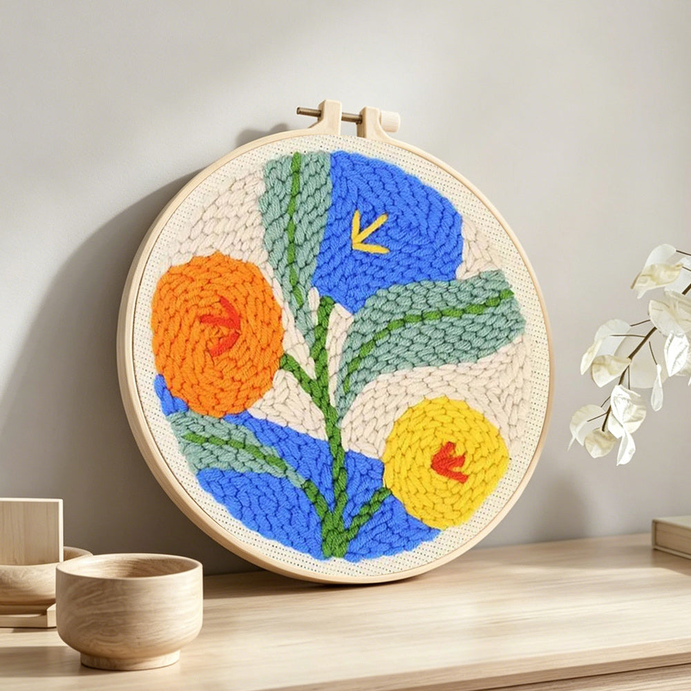 Orange, blue and yellow blooms punch needle artwork displayed on a table
