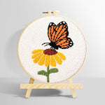 Orange butterfly resting on flower punch needle kit for beginners