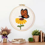 Finished orange butterfly resting on flower artwork displayed on a wall