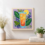 Finished orange cocktail, blueberries and botanical leaves artwork displayed on a wall