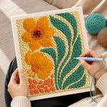Creating handmade orange flowers with giant leaves punch needle artwork