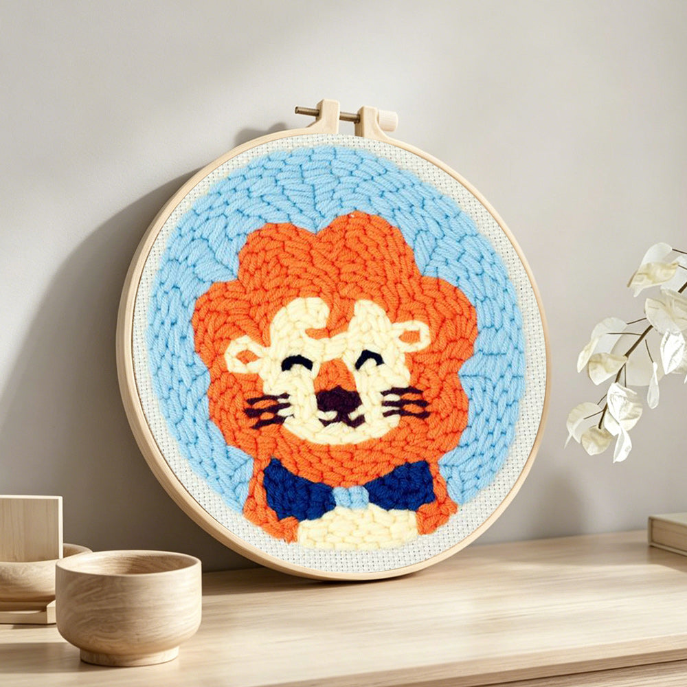 Orange-maned cartoon lion punch needle artwork displayed on a table