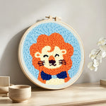 Orange-maned cartoon lion punch needle artwork displayed on a table