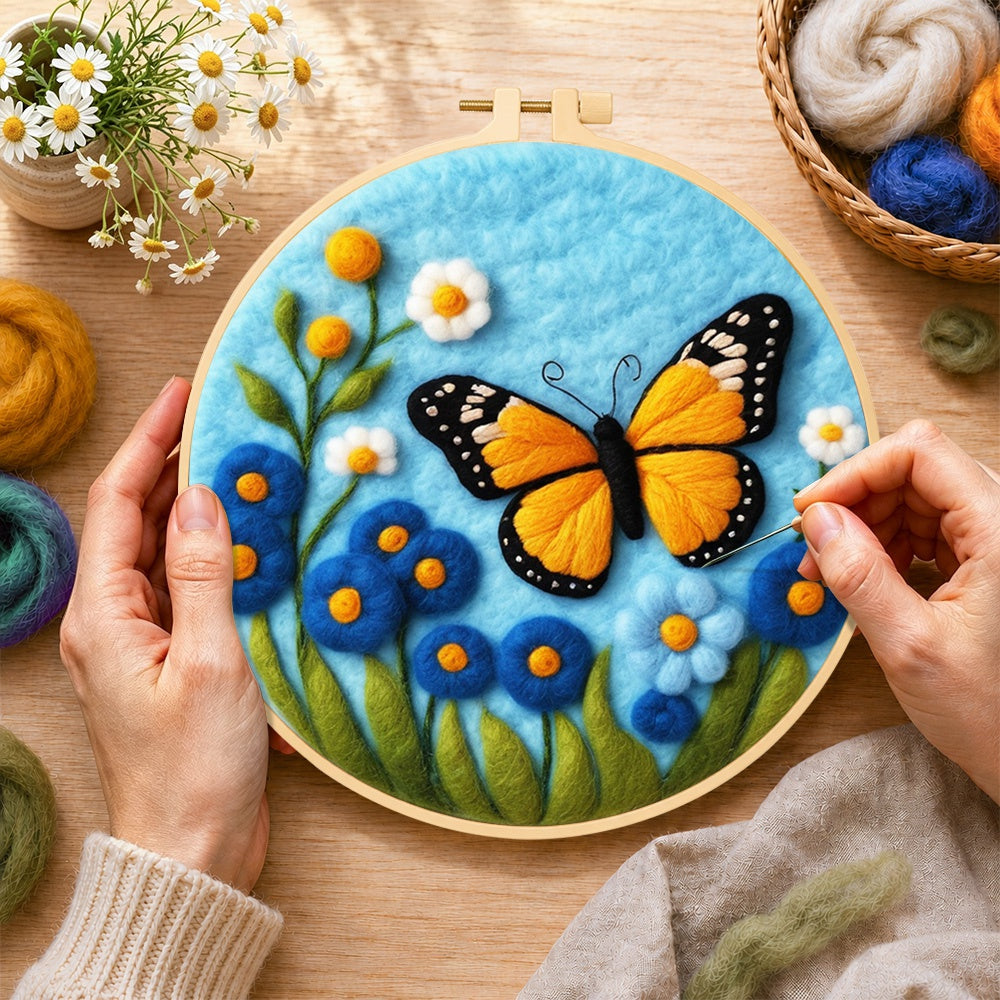 Creating the orange monarch butterfly and blue flowers wool painting by hand with a felting needle