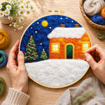 Creating the orange snowy house and christmas trees wool painting by hand with a felting needle