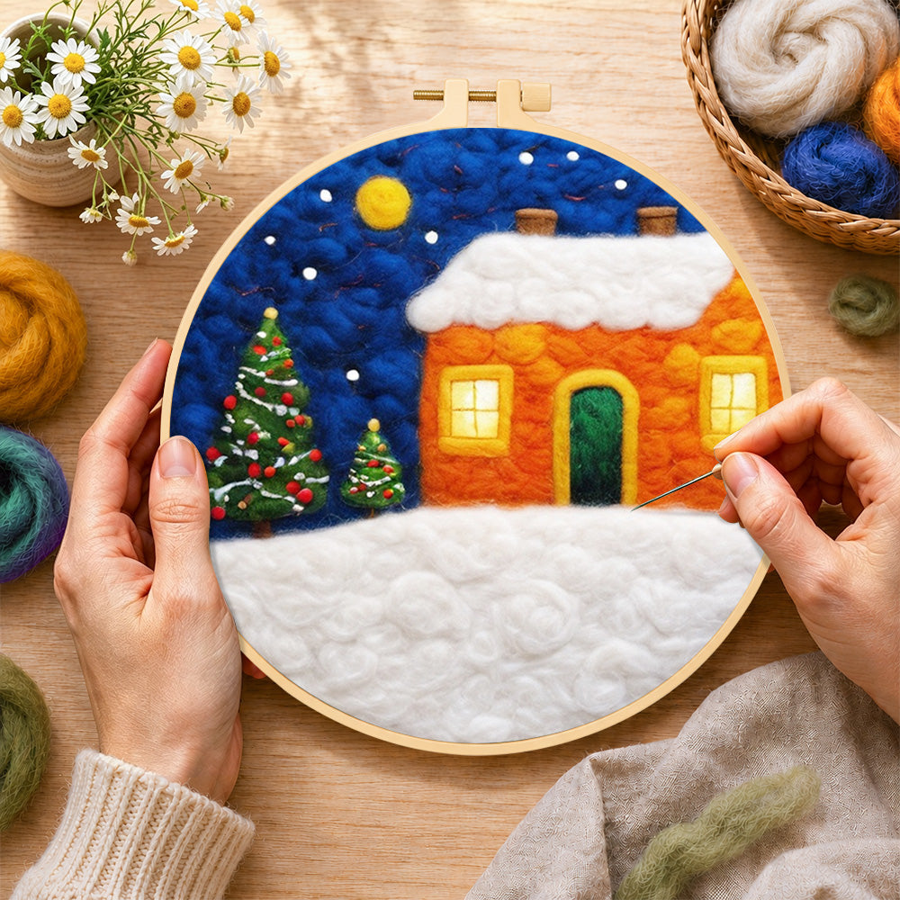 Creating the orange snowy house and christmas trees wool painting by hand with a felting needle