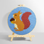 Orange squirrel holding pine cone punch needle kit for beginners