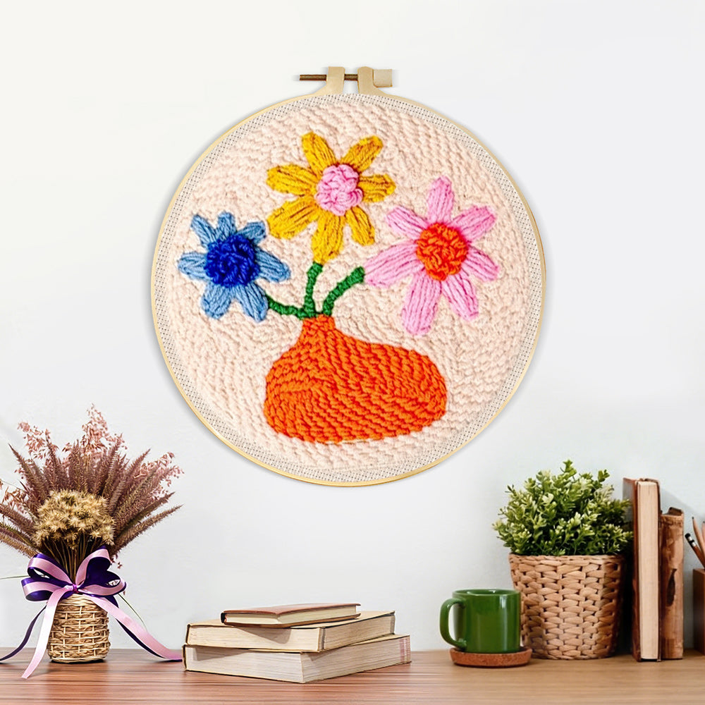 Finished orange vase with colourful flowers artwork displayed on a wall