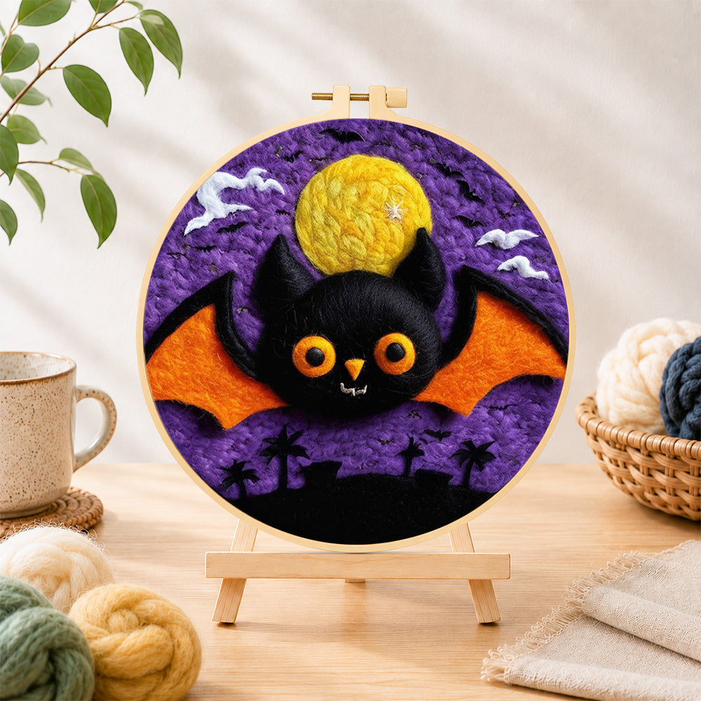 Finished orange-winged bat under the purple night needle felting displayed on a wooden easel