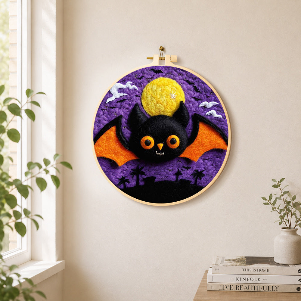 Orange-winged bat under the purple night needle felt wall art displayed in a bright home interior