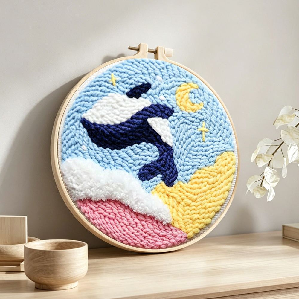 Orca and moon punch needle artwork displayed on a table