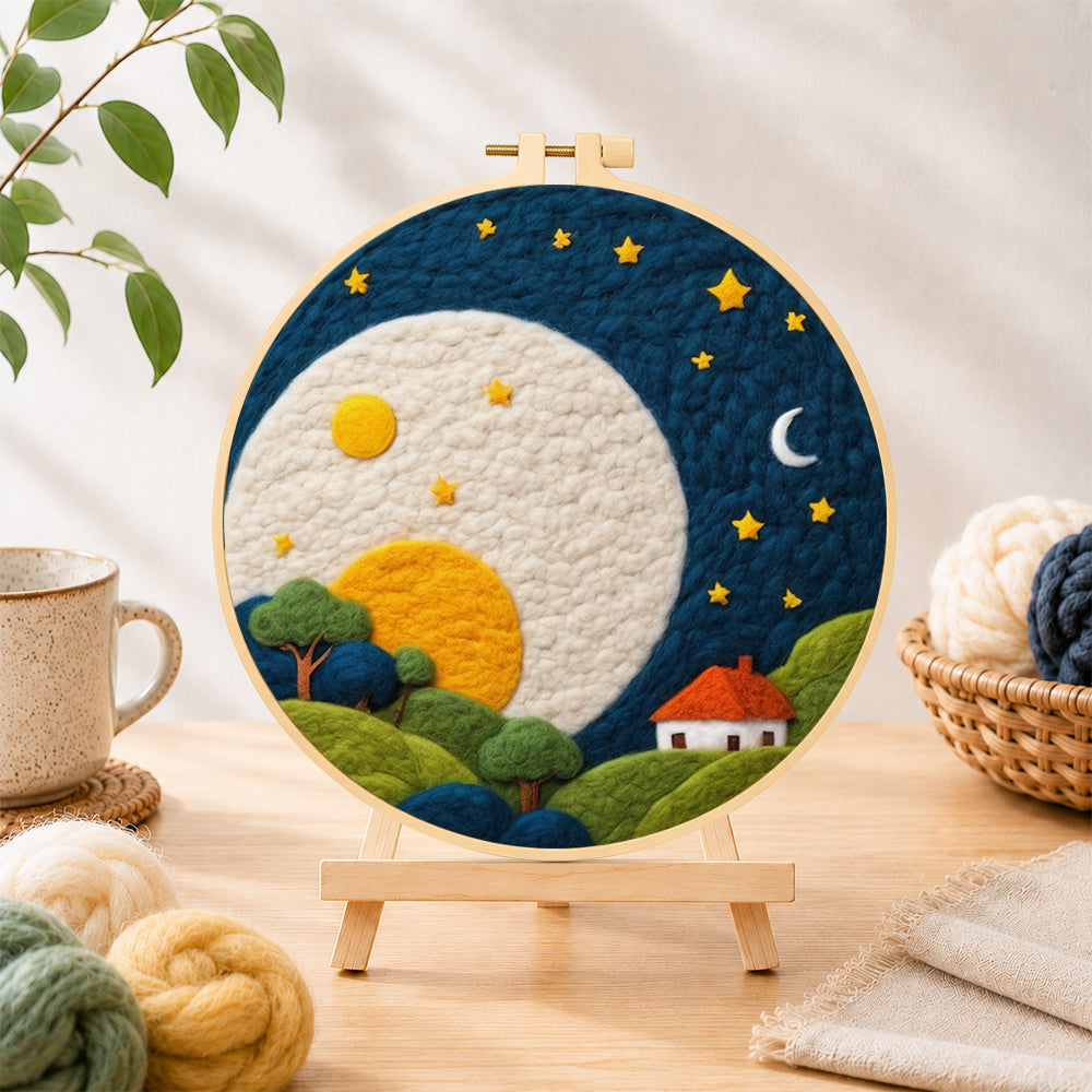Finished oversized moon over red-roof cottage needle felting displayed on a wooden easel