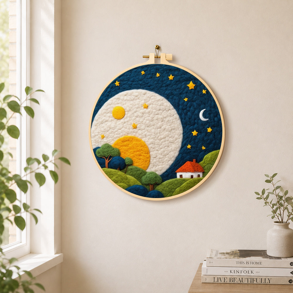 Oversized moon over red-roof cottage needle felt wall art displayed in a bright home interior