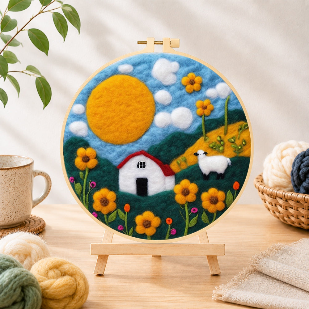 Finished oversized sun and sheep meadow needle felting displayed on a wooden easel