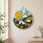Oversized sun and sheep meadow needle felt wall art displayed in a bright home interior