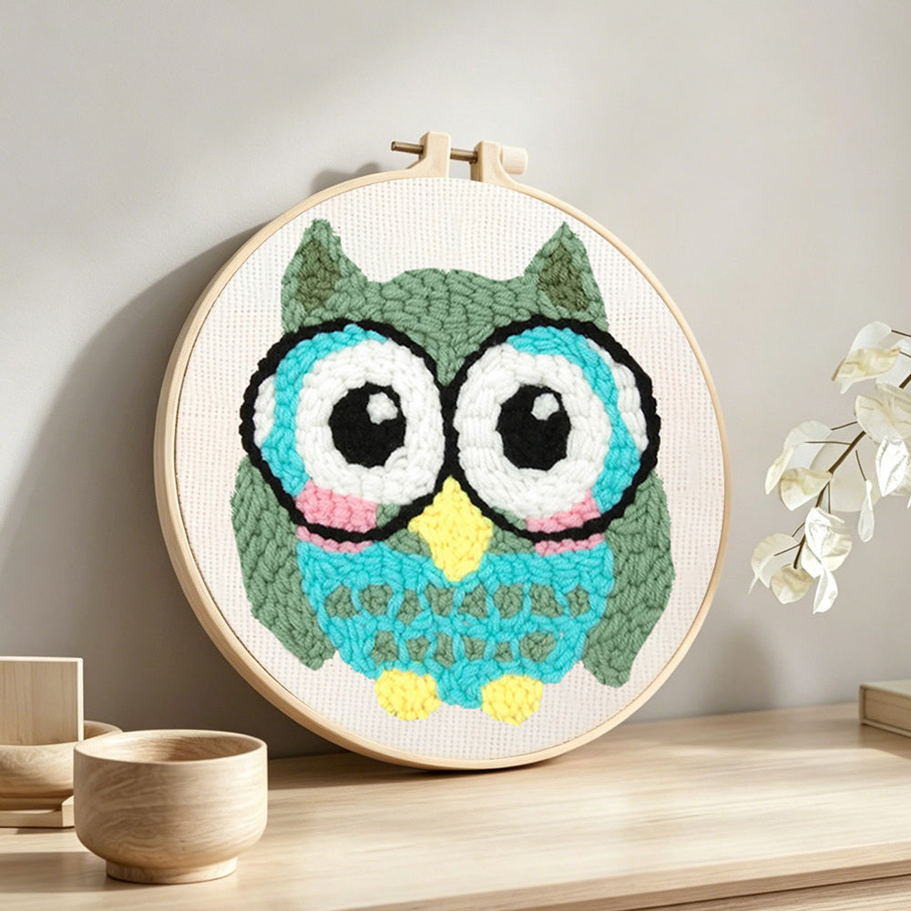 Owl with glasses punch needle artwork displayed on a table