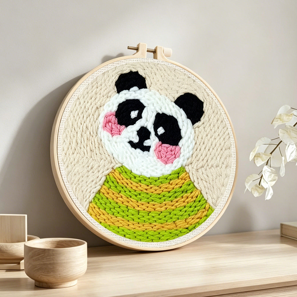Panda in green striped sweater punch needle artwork displayed on a table
