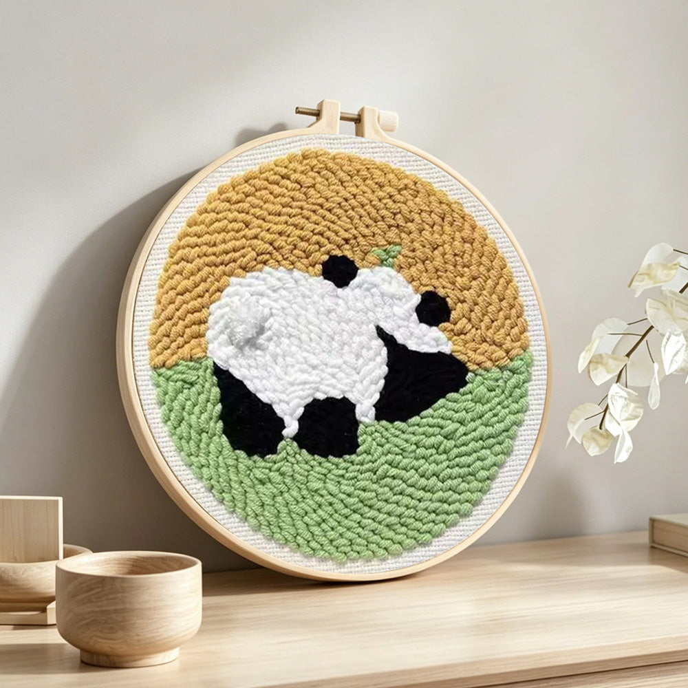 Panda in the meadow punch needle artwork displayed on a table