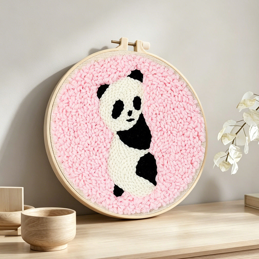 Panda on pink background punch needle artwork displayed on a table