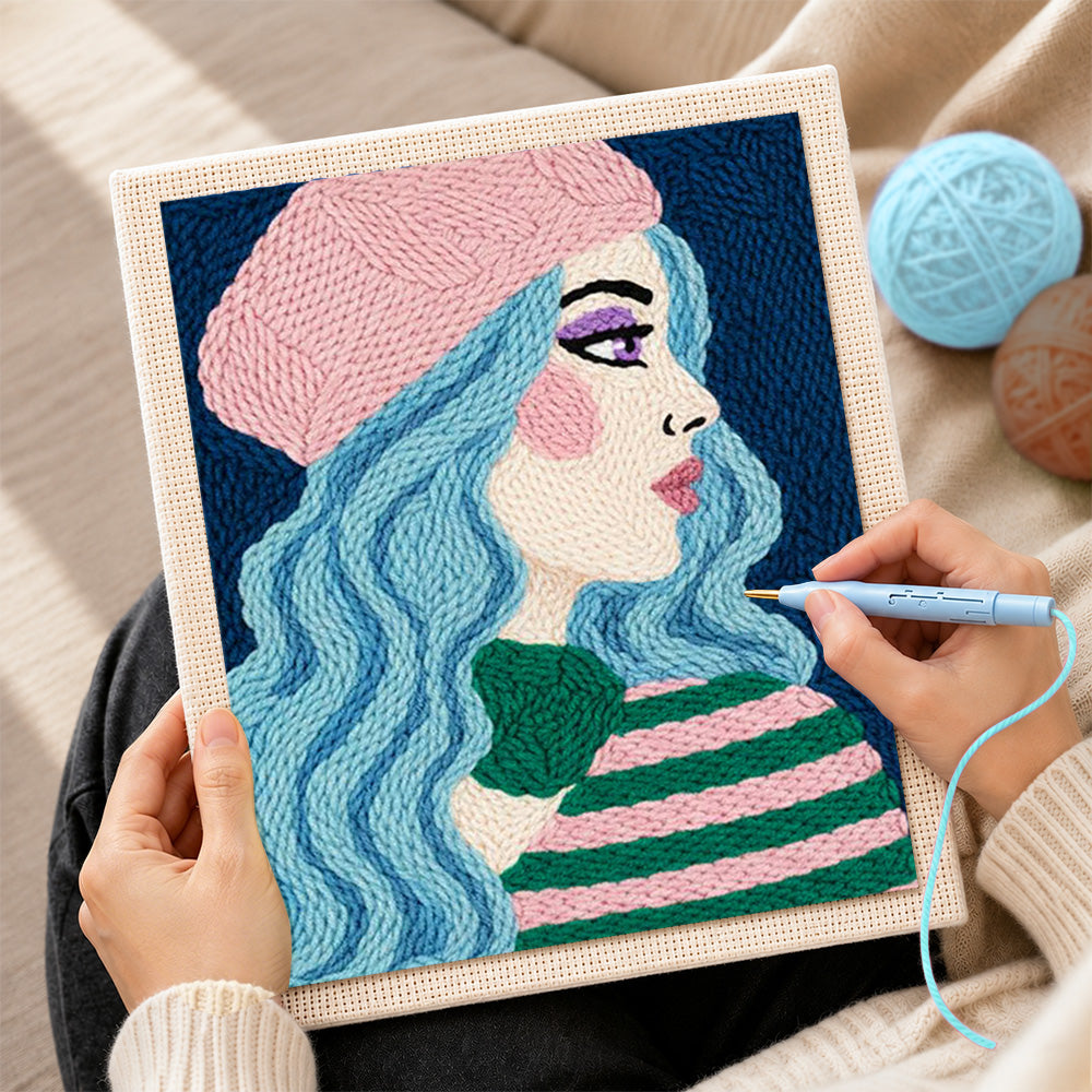 Creating handmade pastel blue haired woman in pink beret punch needle artwork
