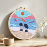 Peaceful beach view with couple punch needle artwork displayed on a table
