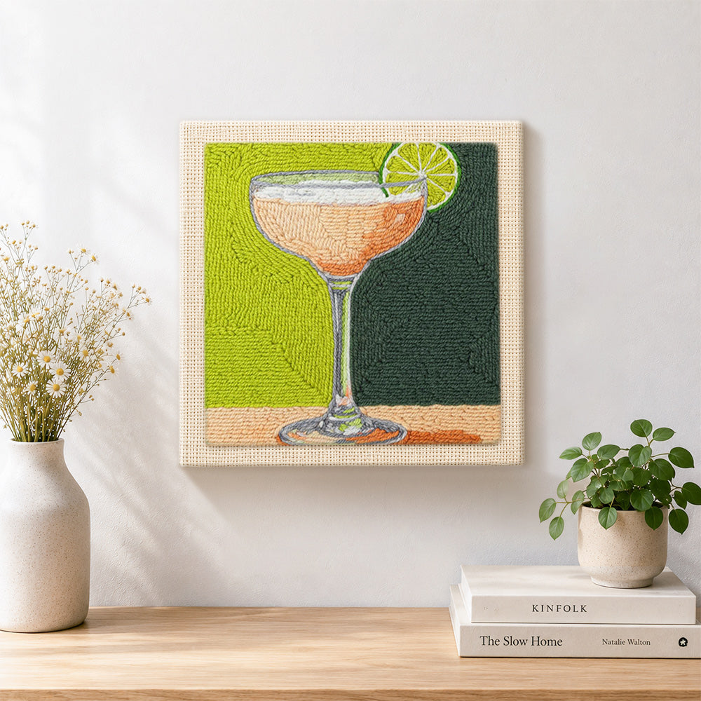 Finished peach drink with lime garnish artwork displayed on a wall