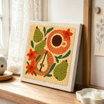Pear, coffee and flowers punch needle artwork displayed on a table