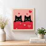 Finished peeking black cat duo with green eyes artwork displayed on a wall