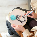 Creating handmade penguin with blue balloon pom punch needle artwork