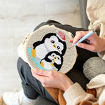 Creating handmade penguin with christmas hat punch needle artwork