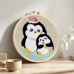 Penguin with christmas hat punch needle artwork displayed on a table