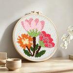 Pink and orange blooms bouquet punch needle artwork displayed on a table