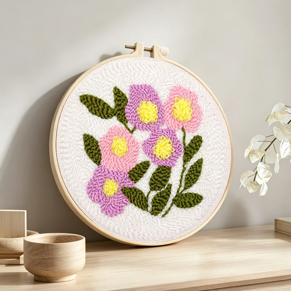Pink and purple bloom cluster punch needle artwork displayed on a table
