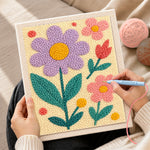 Creating handmade pink and purple flowers punch needle artwork