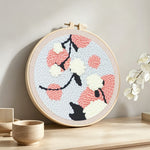 Pink and white blossoms punch needle artwork displayed on a table