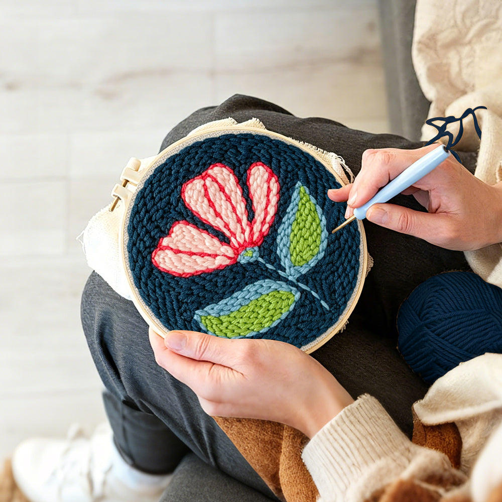 Creating handmade pink and white flower on navy blue punch needle artwork