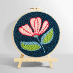 Pink and white flower on navy blue punch needle kit for beginners