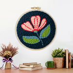 Finished pink and white flower on navy blue artwork displayed on a wall