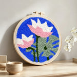 Pink and white lotus punch needle artwork displayed on a table