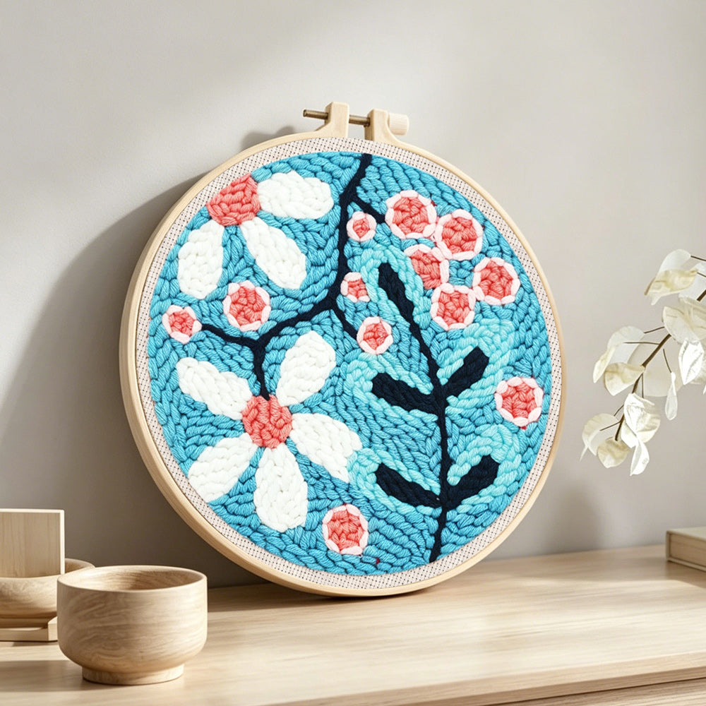 Pink and white sakura punch needle artwork displayed on a table