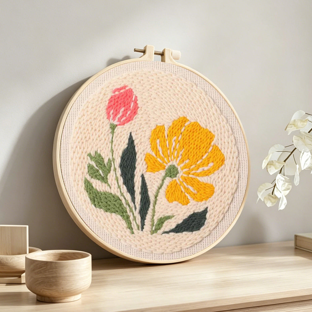 Pink and yellow wildflowers punch needle artwork displayed on a table