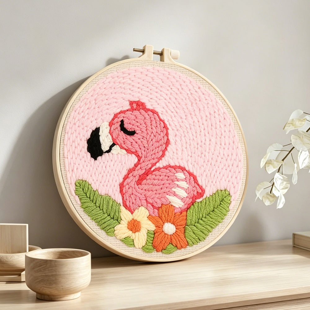 Pink baby flamingo punch needle artwork displayed on a table