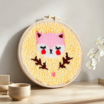 Pink baby fox punch needle artwork displayed on a table