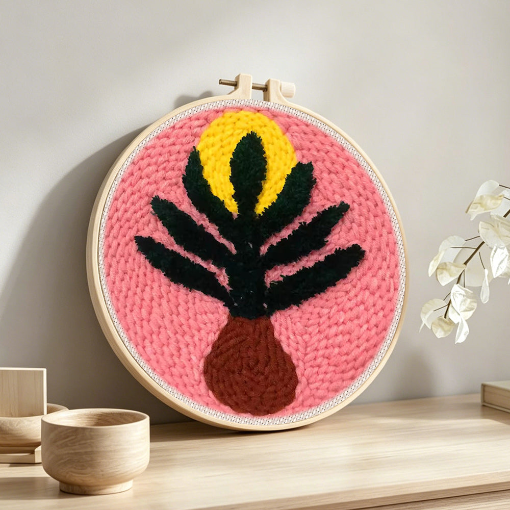 Pink background botanical vase punch needle artwork displayed on a table