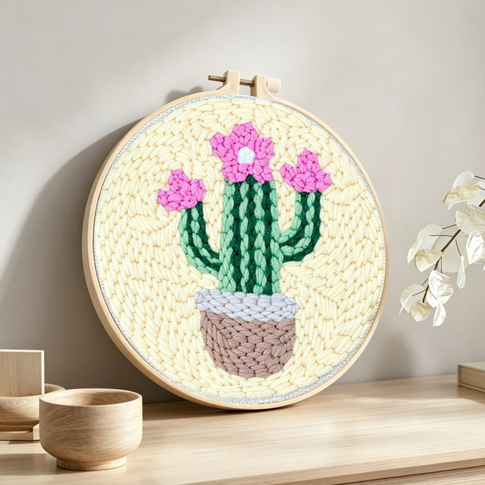 Pink blooming cactus punch needle artwork displayed on a table