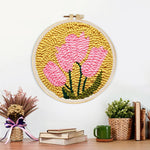 Finished pink blooms on mustard yellow background artwork displayed on a wall