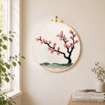 Pink blossom on black branch needle felt wall art displayed in a bright home interior