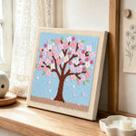Pink cherry blossom tree punch needle artwork displayed on a table